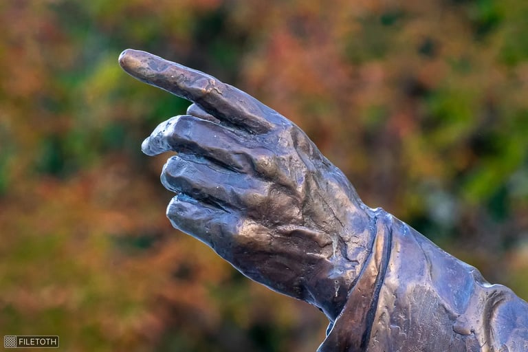 Close-up of George H. W. Bush statue’s outstretched hand, suggesting diplomatic guidance.