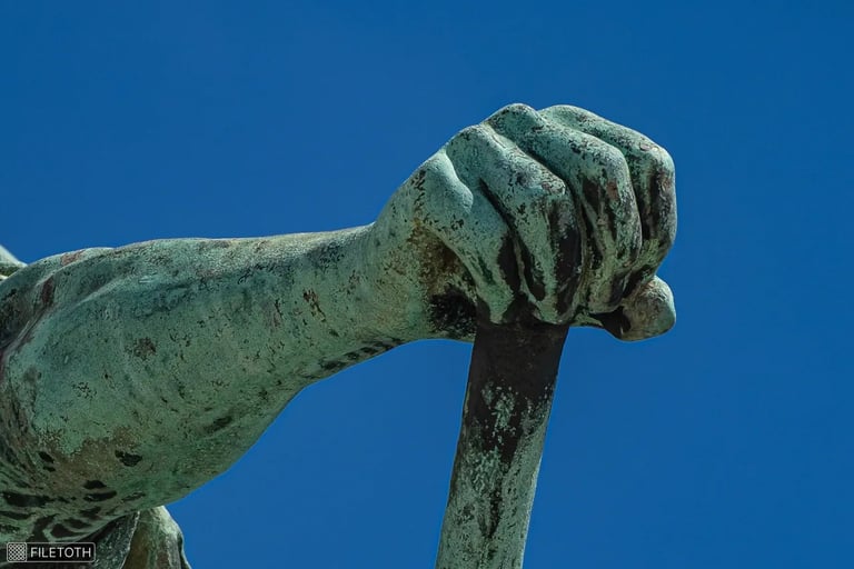 Close-up of Árpád's hand resting on a ceremonial mace against a blue sky.