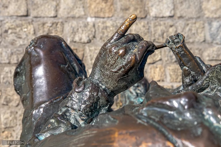 Overhead view of Hilda Gobbi’s bronze hand, little finger pointed with precise gesture.