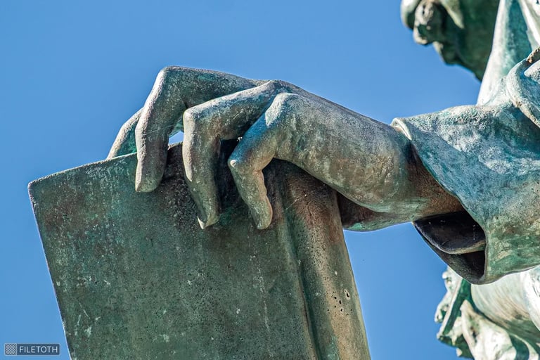 Close-up of János Arany’s hand resting on a book, suggesting literary legacy.