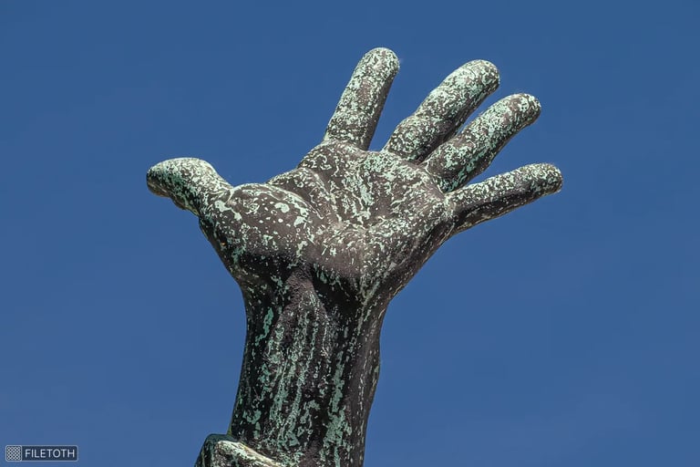 Close-up of Capistrano’s left hand in a gesture of calling against a blue sky.