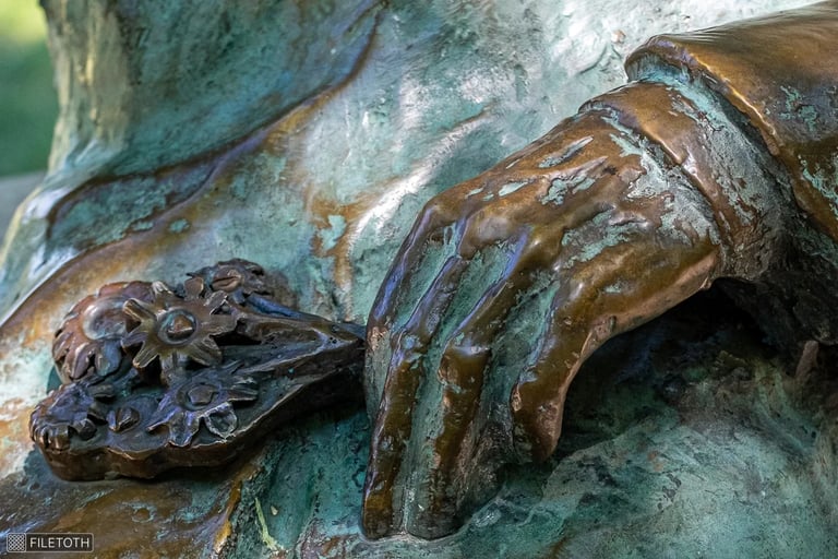 Close-up of Kodály's hand holding a bouquet of wildflowers on the bench.