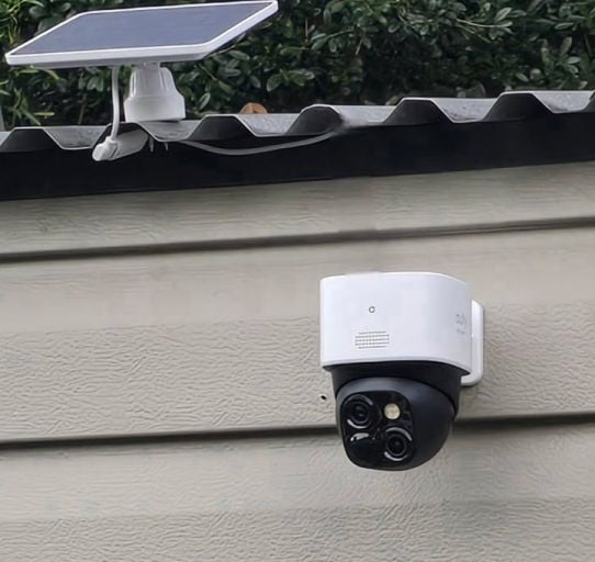 Solar powered wireless outdoor security camera mounted on a residential wall for home surveillance.