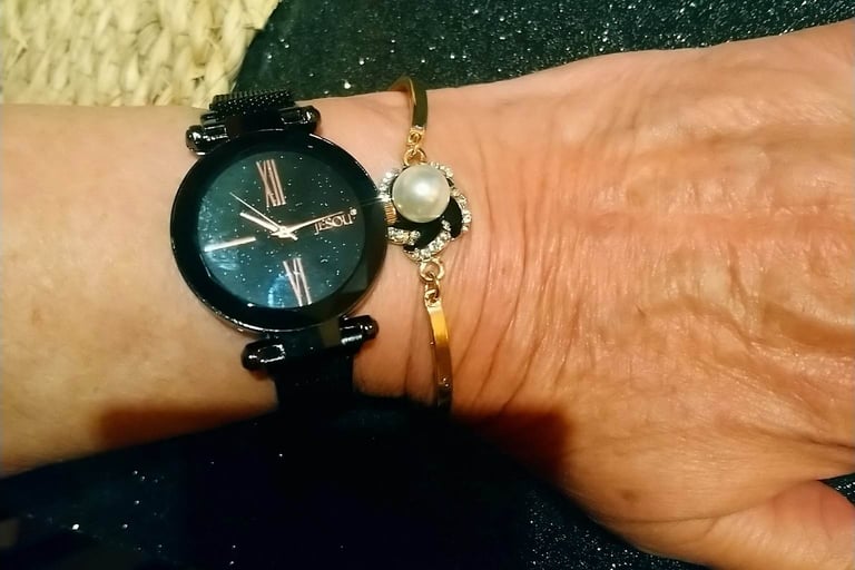 Une femme portant une montre et un bracelet à son poignet