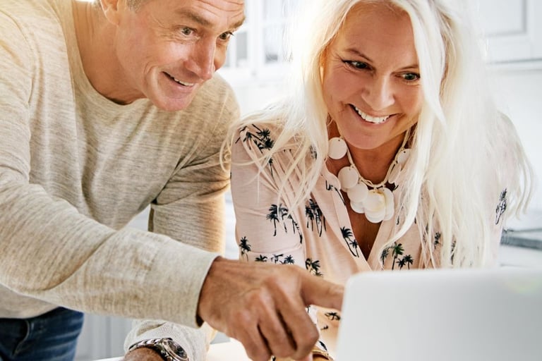 a man and woman looking at a laptop computer