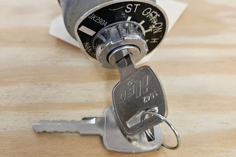 Car ignition switch and key during ignition repair on workbench.