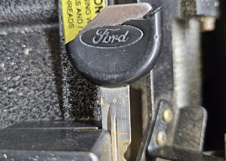Worn Ford key fob with metal key blade on a key ring