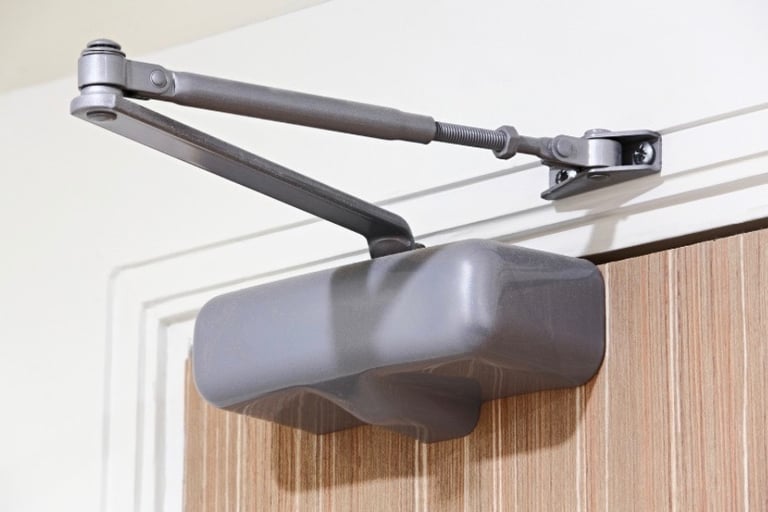 A close-up of a door closer representing Jack’s Locksmith reliable door closer services in Boone, NC