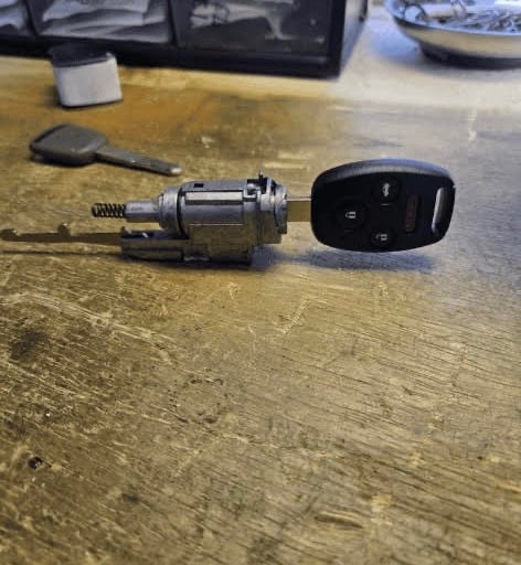 Car key fob and ignition cylinder on a workbench