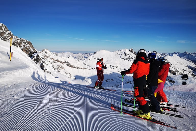 alt= "Ski Gruppe auf der Piste beim Skitechnik besprechen"