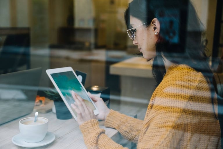 girl with tab and coffee on table