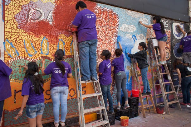 Women artists painting Madhubani artwork.