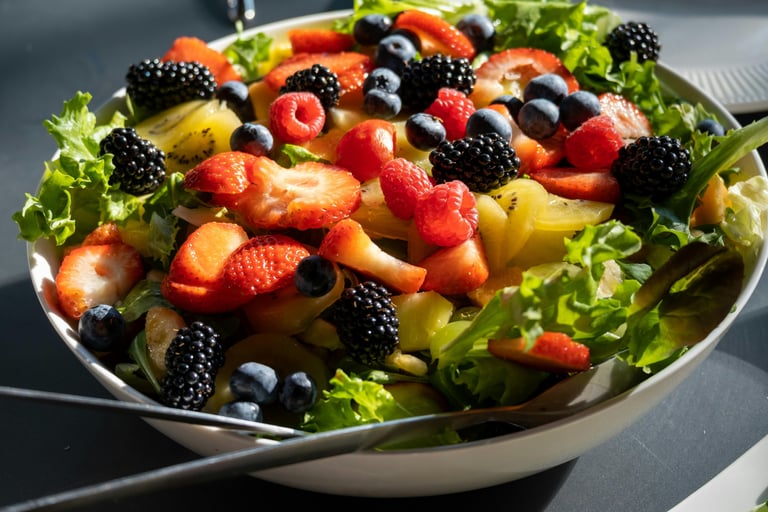 a bowl of fruit salad with berries and berries