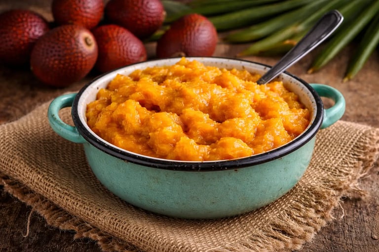 Polpa de buriti amassada servida em uma tigela de cerâmica azul, com frutos inteiros de buriti ao fu