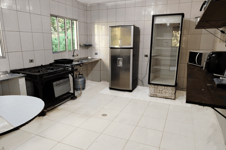 cozinha equipada com duas geladeiras, fogao e forno industrial, microondas, air fryer e duas pias
