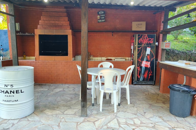 area gourmet ao lado da piscina, com churrasqueira, geladeira, bancada e pia