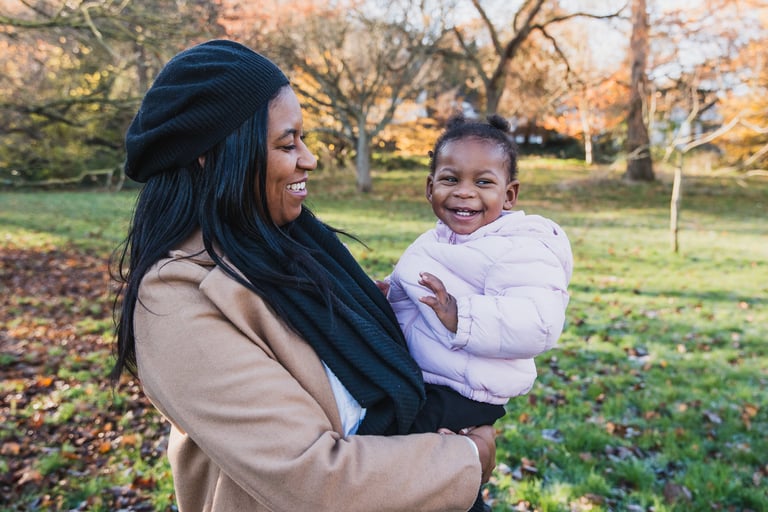 a woman holding her daughter in her arms in an autumn settings in Bexley