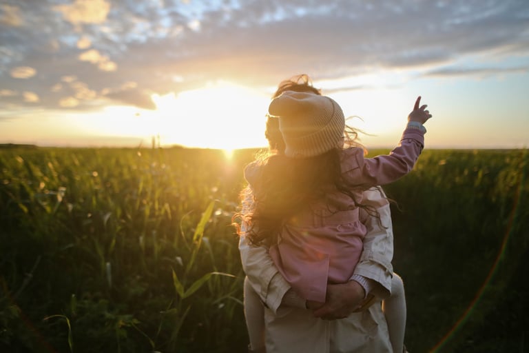 a woman holding a child in a field