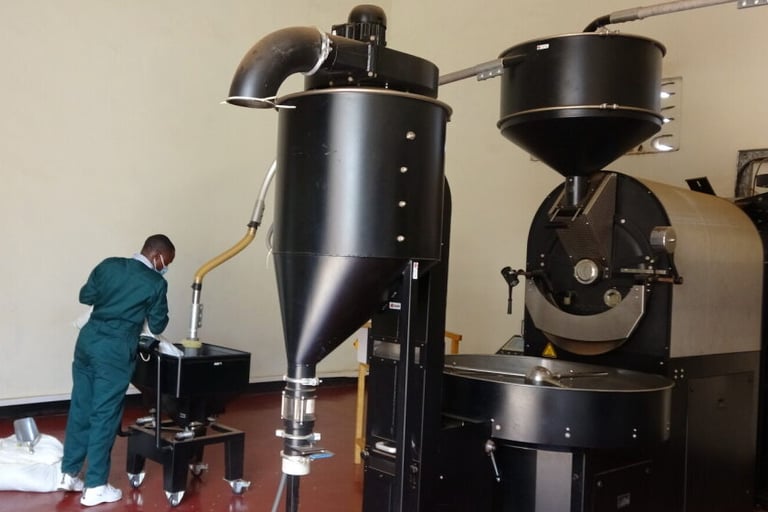 a man in a green uniform is standing in front of a coffee roasting machine