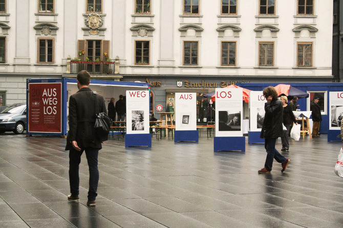 Menschen gehen durch die Ausstellung "Aus weg los!" auf der Grazer Hauptplatz.