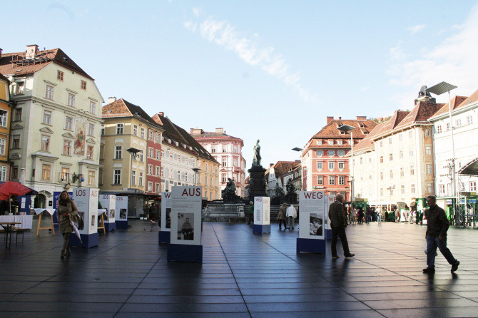 Menschen gehen durch die Ausstellung "Aus weg los!" auf der Grazer Hauptplatz.
