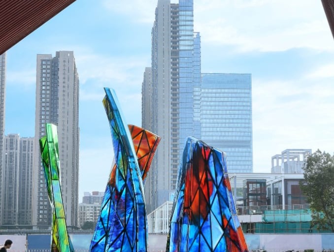 Blooming Sculpture by Shan Shan Sheng in the daytime with the city skyline behind it