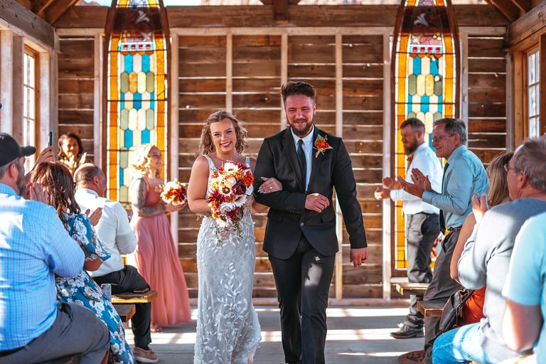 a man and woman walking down the aisle of a wedding chapel