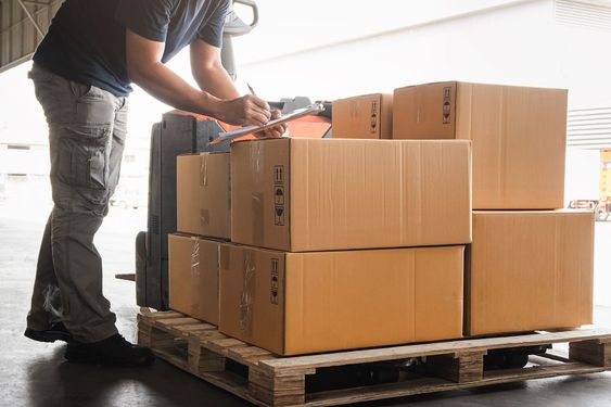 a man is standing in front of a stack of boxes