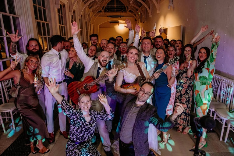 Bride and groom celebrating with family friends and wedding singers and party band