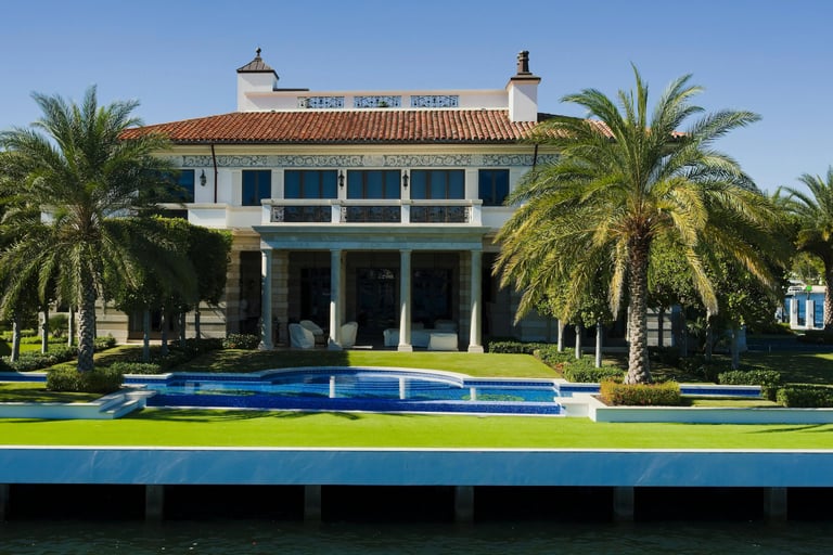 a large house with a pool and palm trees