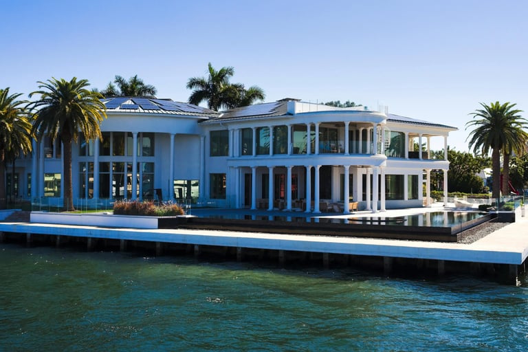 a large house with a dock and palm trees