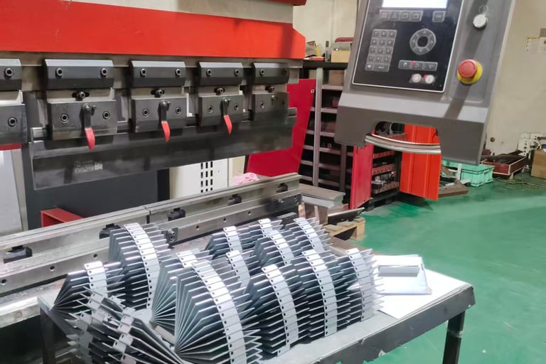 Industrial CNC press brake machine bending sheet metal parts in a manufacturing facility.