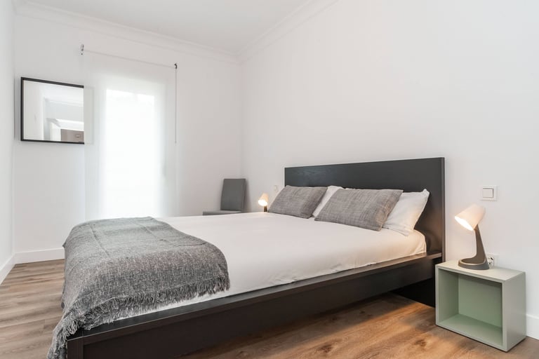 Double bedroom with dark wood bed frame, Anne apartment San Sebastian