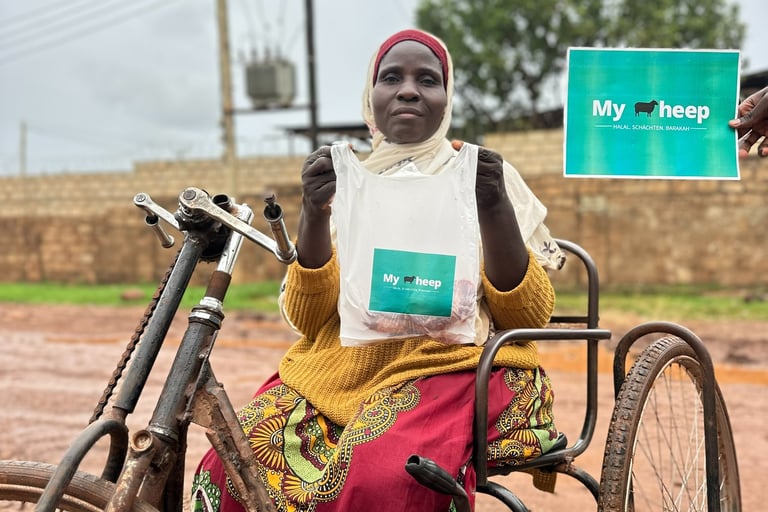 Bedürftige Frau mit Einschränkungen erhält Fleischspende in Uganda durch MySheep