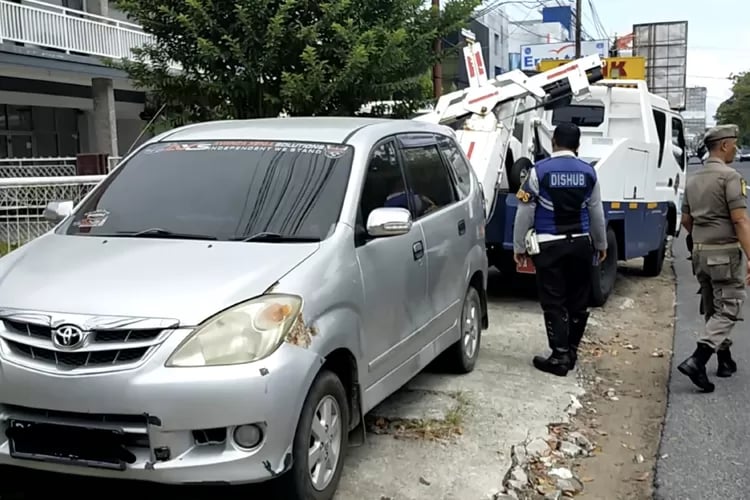 a man in a blue shirt is standing next to a white van