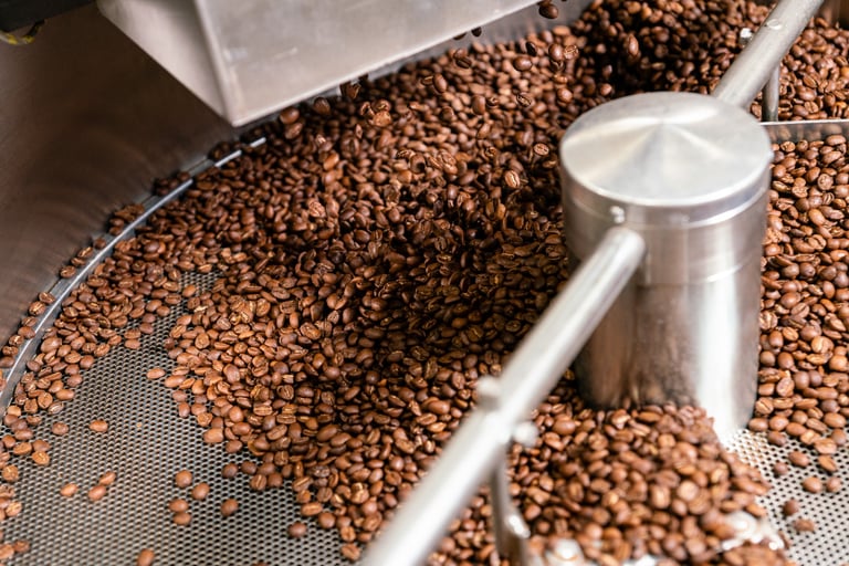 Chicchi di caffè in tostatrice durante il processo di lavorazione