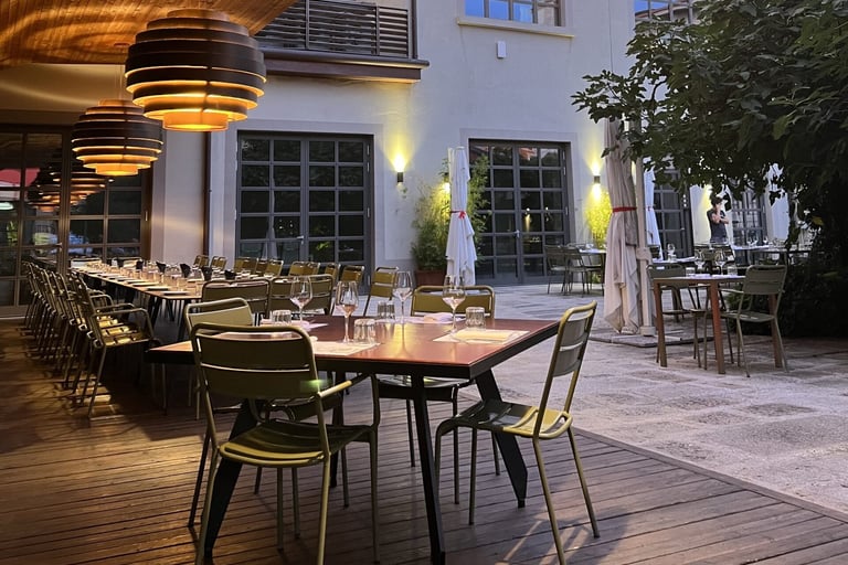 Il giardino di Pa.Lato Milano con tavoli all’aperto e illuminazione serale