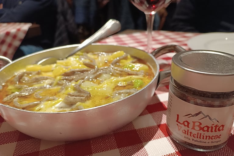 Piatto di pizzoccheri della tradizione valtellinese serviti a tavola