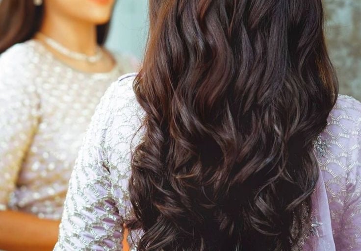 Elegant bridal hairstyle with soft curls and floral hair accessories.