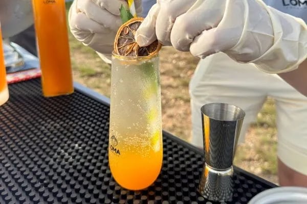 Close-up of a Loma mixologist preparing a hand-garnished artisanal cocktail.