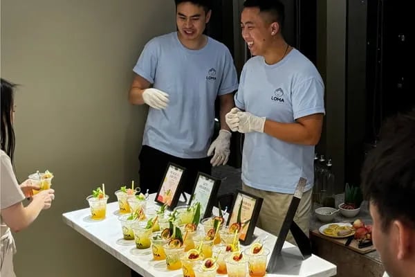 Loma bartender presenting a bespoke drink concept to a happy customer.