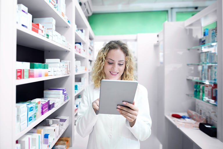 a woman in a pharmacy office setting holding a tablet computer