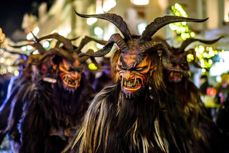 Traditional Krampus figures with terrifying masks and horns during a festive European winter parade.