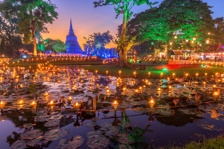 Floating candles on a lotus pond at Sukhothai Historical Park during the Loy Krathong festival in Thailand.