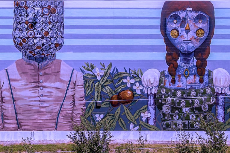 a mural of a man and woman in front of a mural of a woman in Downtown St. Petersburg