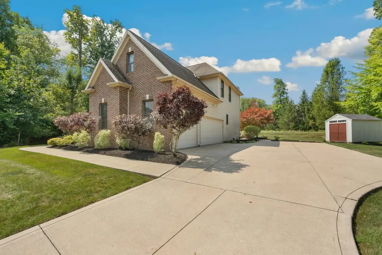 a house with a  concrete driveway and garden