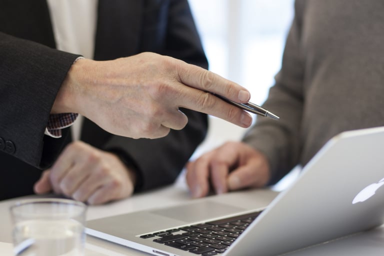 persona trabajando en la computadora con un compañero