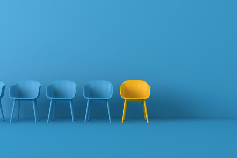 a row of chairs with a yellow chair and a blue wall