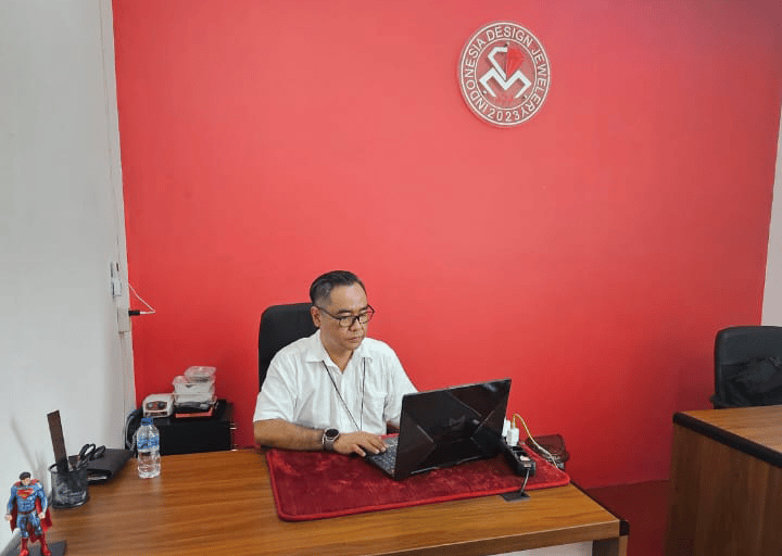 a man sitting at a desk with a laptop computer