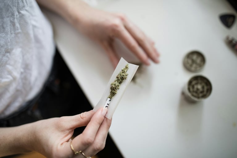 a person holding a piece of paper with a marijuana leaf